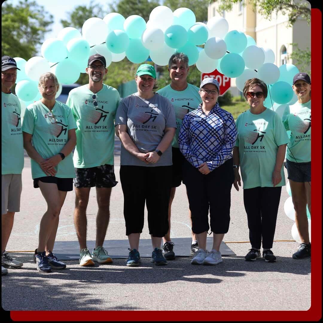 The Heritage All Day 5K team members standing under a balloon arch